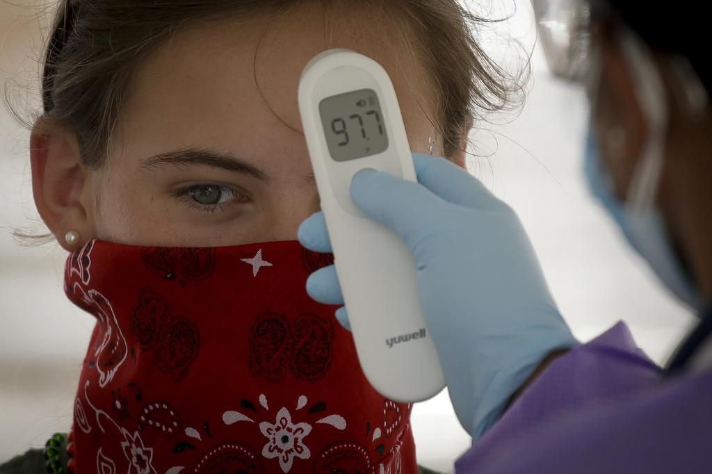 Kritik an Trump, weil er einen Event mit tausenden Menschen inmitten der Pandemie abgehalten hat: Bei einer Anhängerin wird die Temperatur gemessen. (20. Juni 2020)