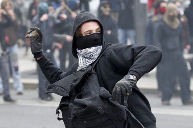 Un étudiant jette une pierre contre les forces de l'ordre devant le Palais des congrès à Montréal.