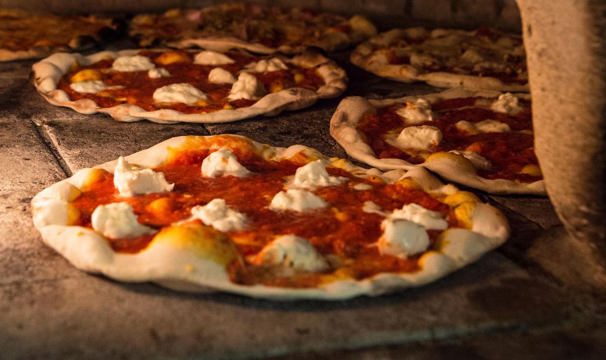 In ihrer geschützten Urform kommt die Pizza aus einem Holzofen: Eine neapolitanische 2-Kilometer-MEGA-Pizza, die den Weltrekord für die längste Pizza gebrochen hat.  