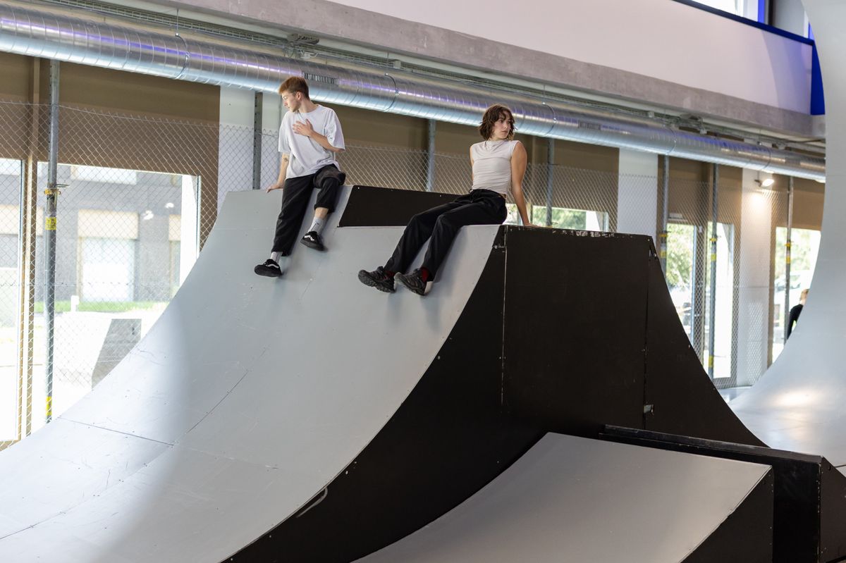 Deux personnes assises au sommet d'une rampe de skate à l'intérieur de l'UMA - Urban Move Academy à Vernier, lors de son inauguration le 25 septembre 2024.