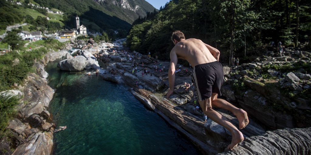 Ein Tourist sucht mit einem Sprung in die Verzasca Abkühlung.