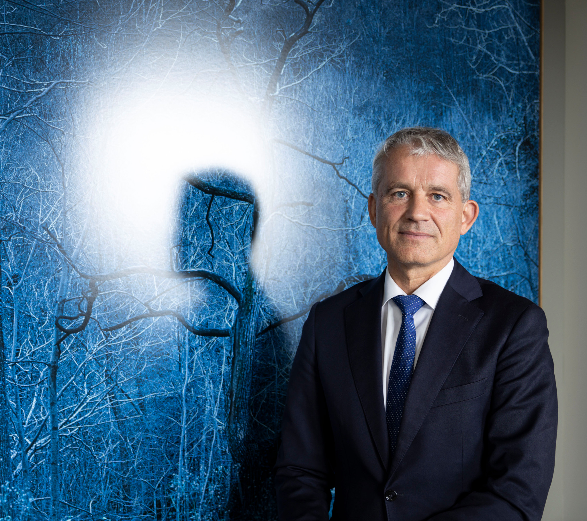 Beat Jans en costume pose devant un tableau bleu pendant une interview sur l’abstimmung E-ID.