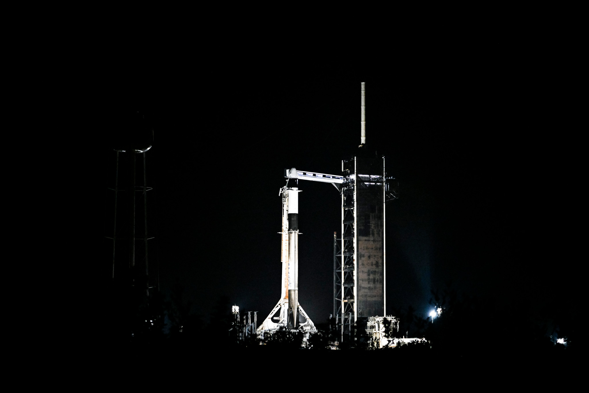 A SpaceX Falcon 9 rocket with the Crew Dragon Resilience capsule sits on Launch Complex 39A at Kennedy Space Center ahead of the Polaris Dawn Mission in Cape Canaveral, Florida, on August 28, 2024. SpaceX on August 28, postponed once more its attempt at launching a daring orbital expedition featuring an all-civilian crew that is aiming to carry out the first-ever spacewalk by private citizens. (Photo by CHANDAN KHANNA / AFP)