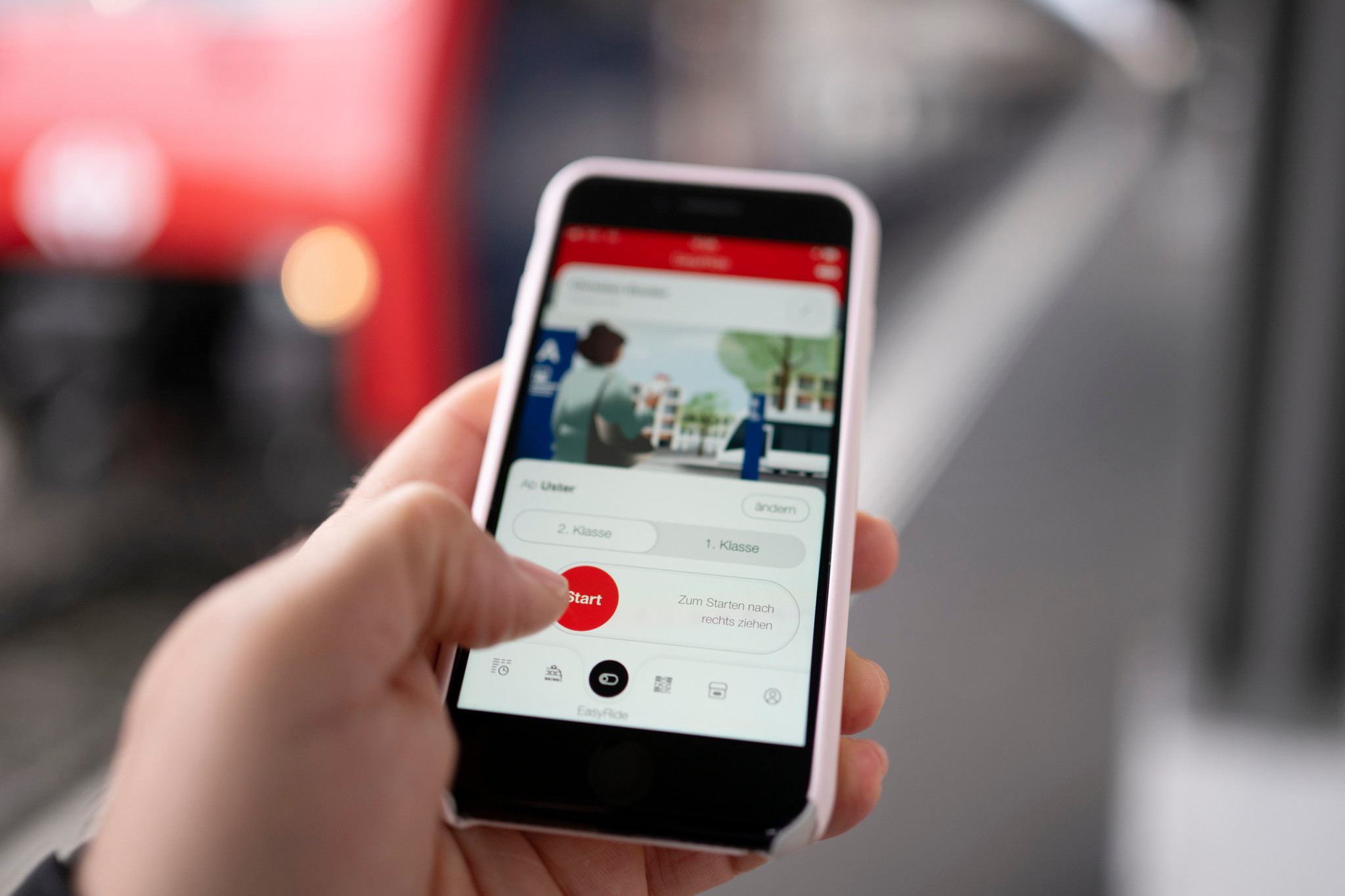 Hand hält Smartphone mit geöffneter EasyRide-Funktion der SBB Mobile App am Bahnhof Uster.