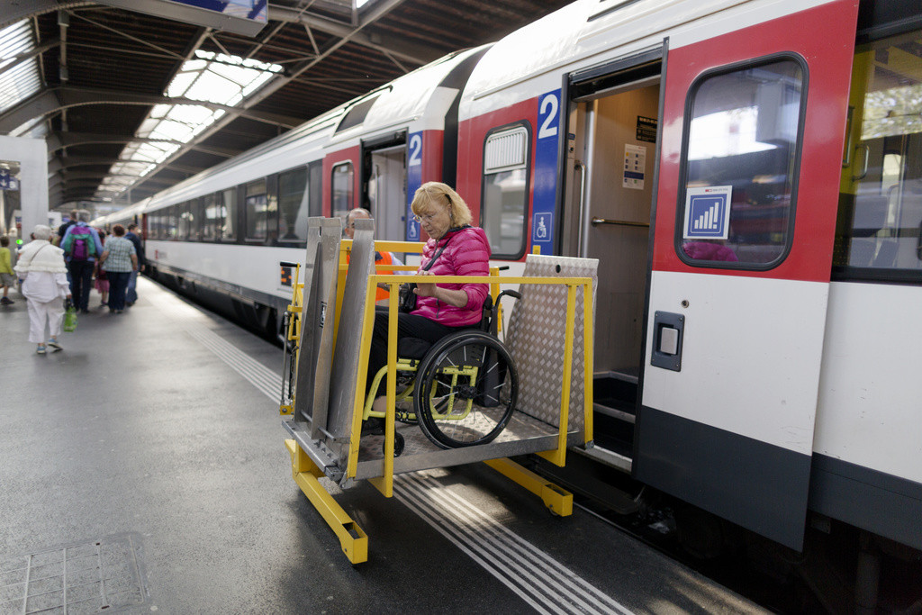 Ein Mitarbeiter der SBB begleitet einen Frau im Rollstuhl. Noch ist das barrierefreie Zugfahren in der Schweiz nicht überall Realität.