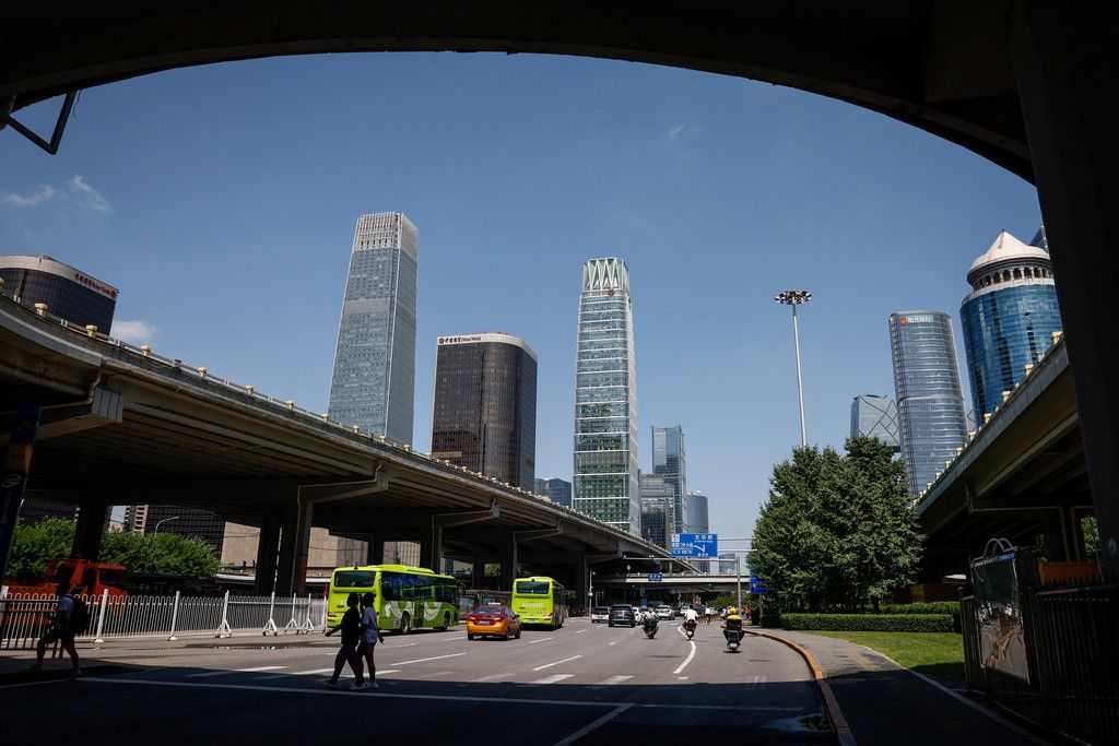 epa10811200 People cross a road in the central business district in Beijing, China, 21 August 2023. The PeopleâÄ™s Bank of China reduced its one-year loan prime rate from 3.55 percent to 3.45 percent while maintaining the five-year loan prime rate to 4.20 percent as the country continues to revive the economy following the Covid pandemic. EPA/MARK R. CRISTINO