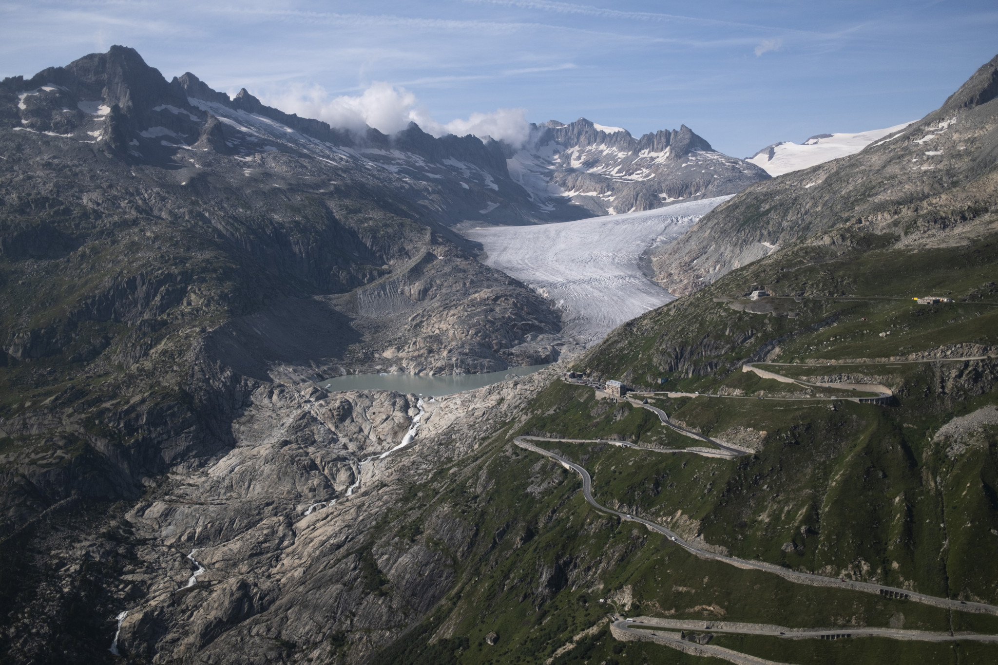 Ansicht des Rhonegletschers und der Furkapass-Strasse im Obergoms, umgeben von Bergen und blauen Himmel, am 21. August 2024.