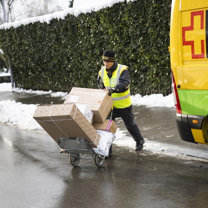Un facteur de la Poste suisse, Vito Bochicchio, livre des colis à Zurich Höngg, pris le mardi 5 décembre 2023.