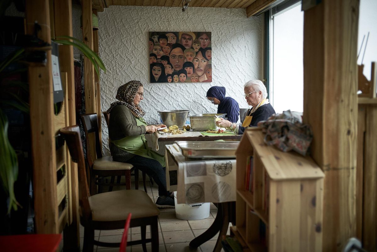 Mahbobe (à gauche), Marianne (à droite) et Nasra (au fond) prépare bénévolement le repas au Verso l’Alto