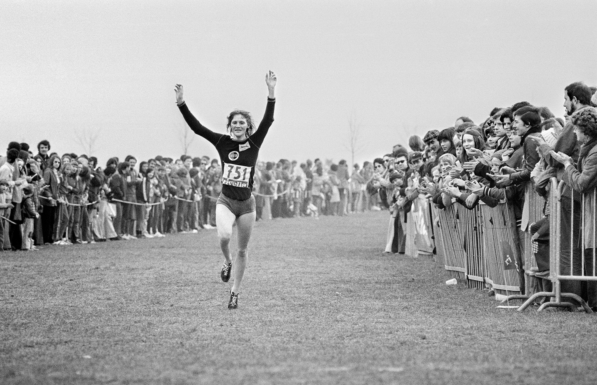 Marijke Moser überquert jubelnd mit erhobenen Armen die Ziellinie beim Cross-Country-Rennen der Schweizer Meisterschaft im März 1975.