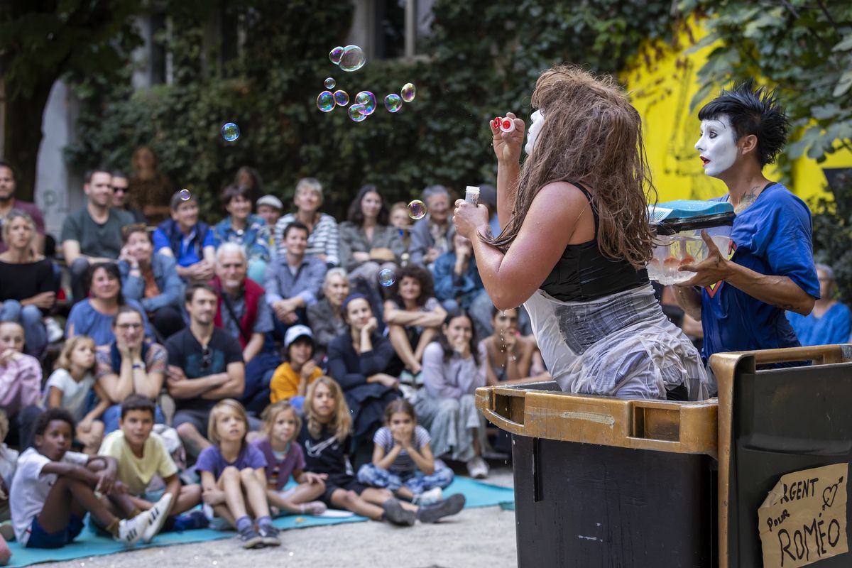 Performance théâtrale lors de la Fête du Théâtre 2023 avec des artistes en costumes et maquillage, entourés d'un public attentif.