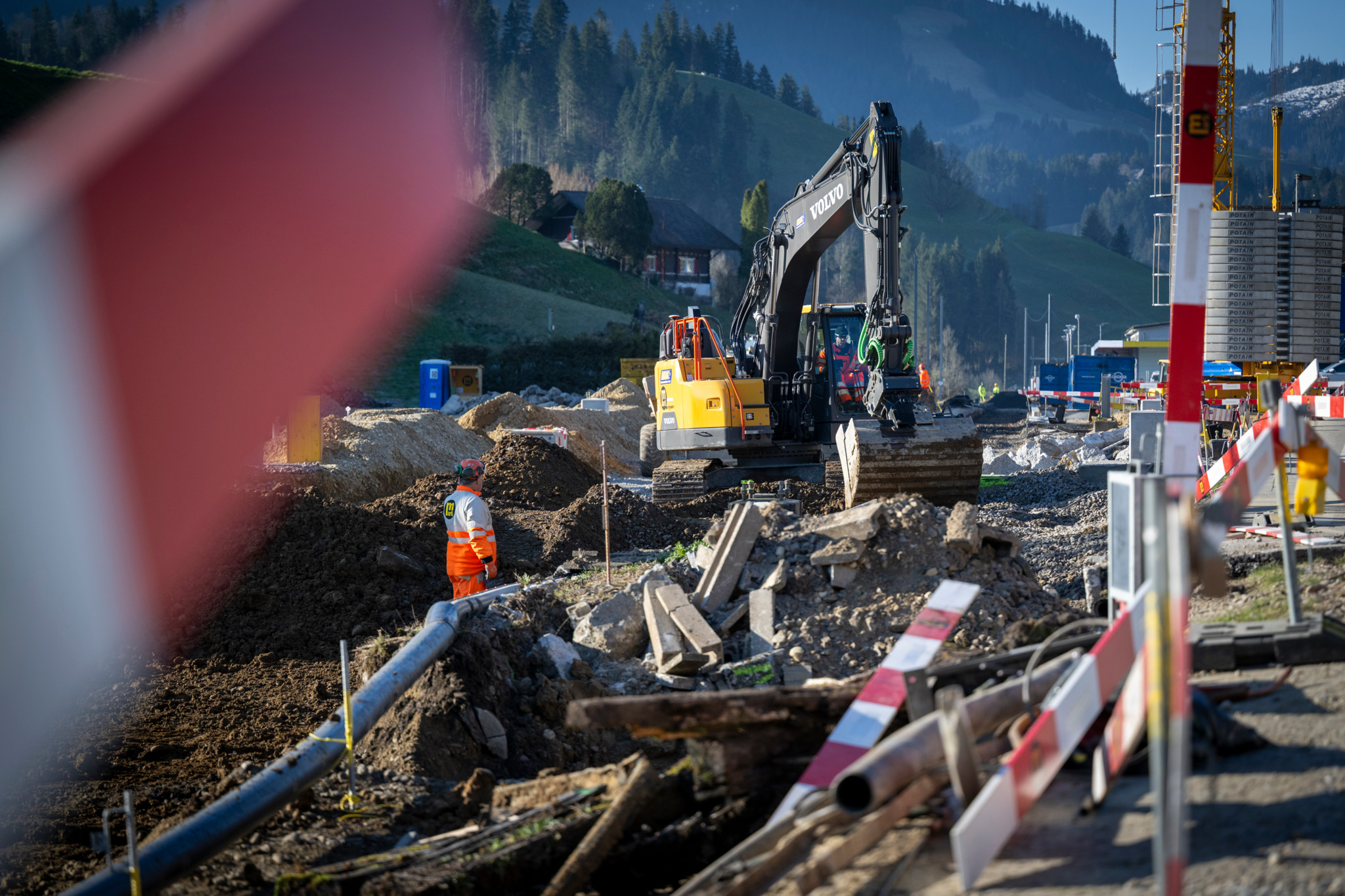 Bauarbeiten am Bahnhof Escholzmatt mit Bagger und Arbeiter. Strecke von Langnau bis Schüpfheim wegen Totalsperre ab 31. März 2025 betroffen.