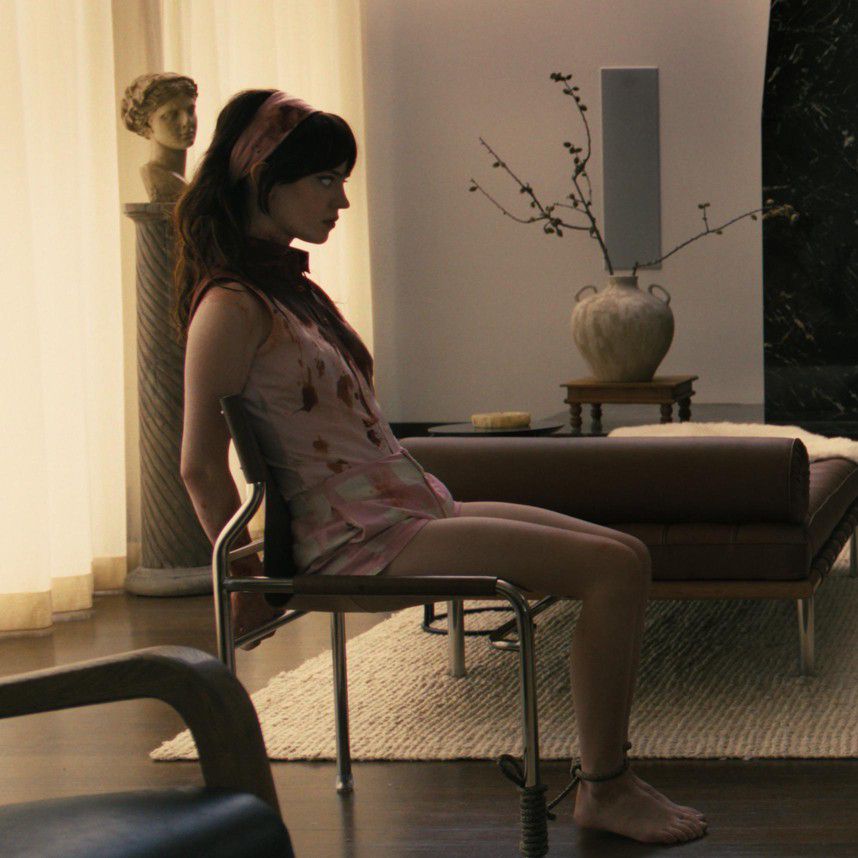 Deux personnes assises l’une en face de l’autre dans un salon moderne avec une grande cheminée en arrière-plan.