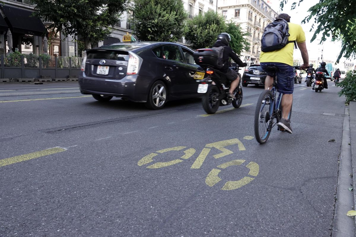 Cycling track on avenue Georges Favon in Geneva, with cyclists and vehicles⁤ traveling in ‌the ‌same direction.