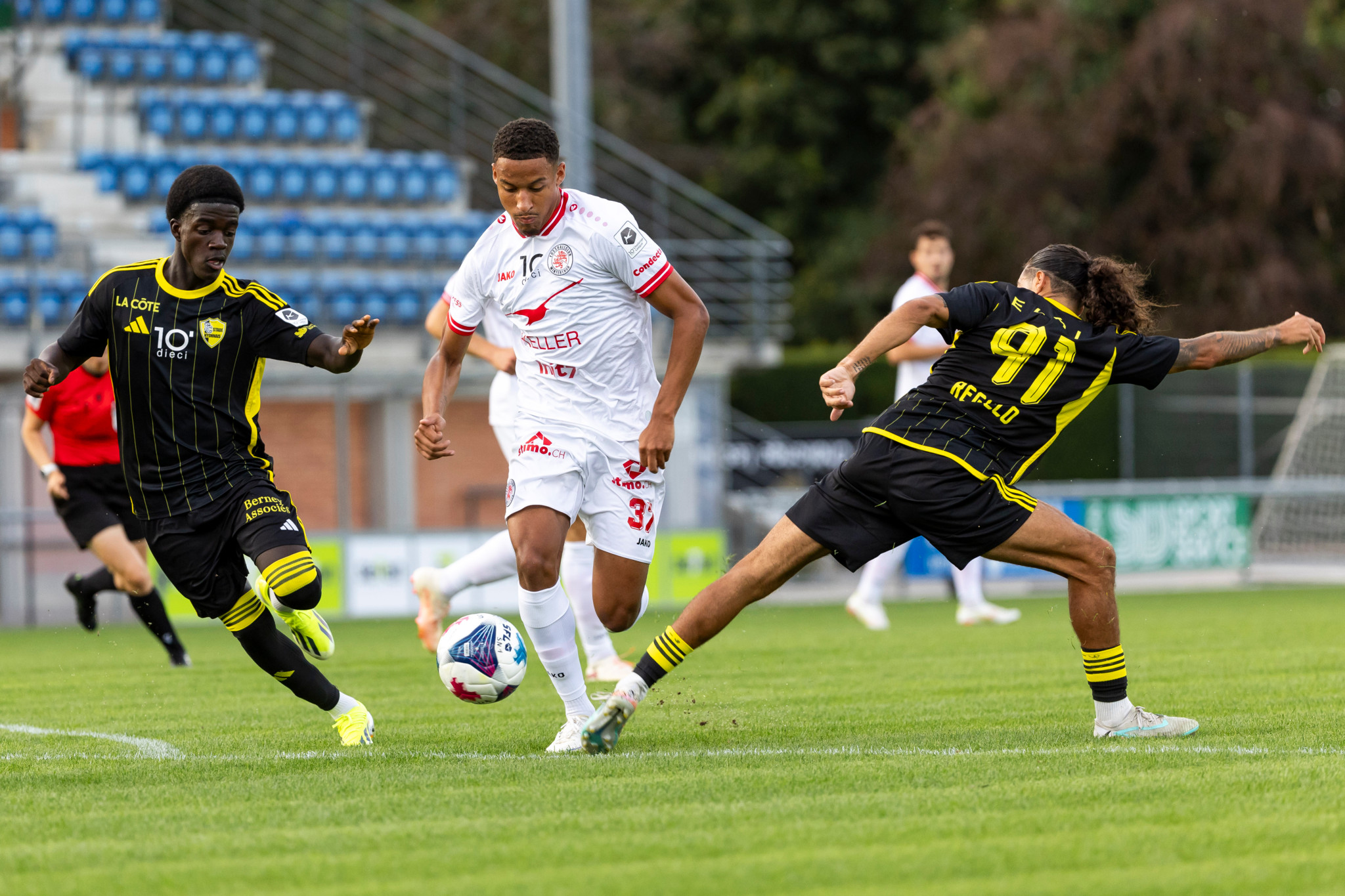 Elias Maluvunu (FC Winterthur, weiss) kämpft gegen Mardochee Miguel und Matteo Regillo (Stade Nyonnais) um den Ball. Challenge League.