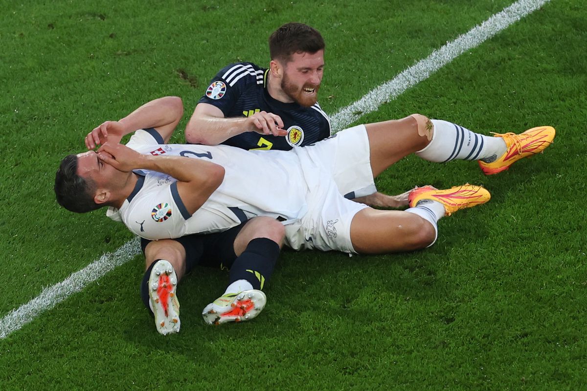 COLOGNE, GERMANY - JUNE 19: Anthony Ralston of Scotland and Fabian Schaer of Switzerland lie on the floor after clashing whilst competing for a header during the UEFA EURO 2024 group stage match between Scotland and Switzerland at Cologne Stadium on June 19, 2024 in Cologne, Germany. (Photo by Alex Grimm/Getty Images)