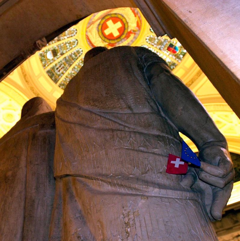 Statues des trois confédérés dans le Bundeshaus avec une carte suisse symbolique dans la main. Plafond décoré en arrière-plan.