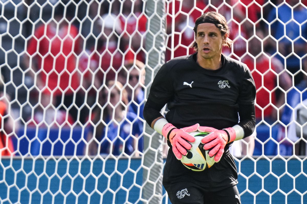 Le gardien suisse Yann Sommer, numéro 01, s'échauffe avant le match de huitième de finale de l'UEFA Euro 2024 contre l'Italie, tenant un ballon devant le but au Olympiastadion Berlin.