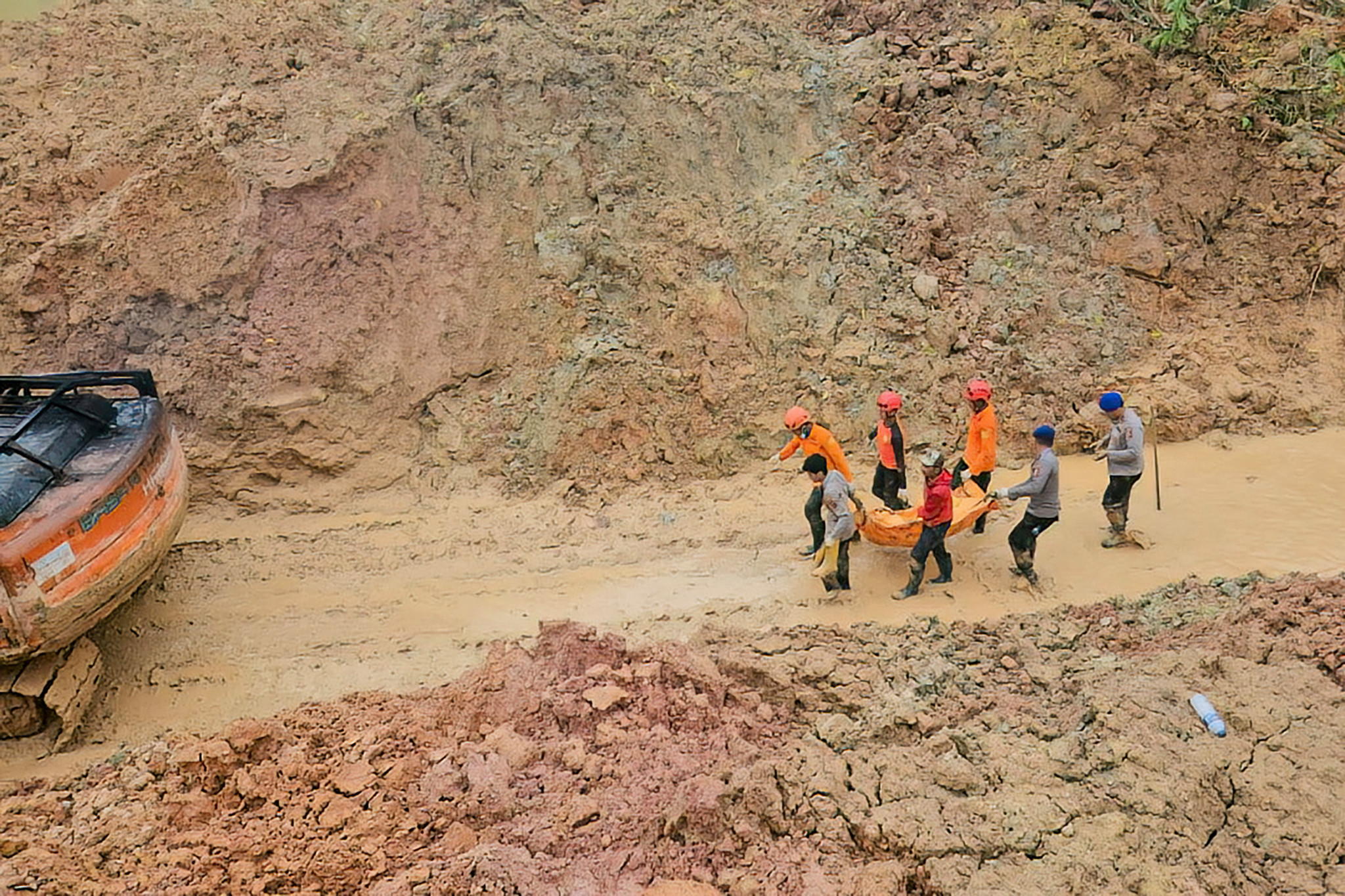 Équipe de secours transportant les restes d’une victime de glissement de terrain dans un sac mortuaire, dans le village de Pagaran Lambung, province de Sumatra du Nord, Indonésie.
