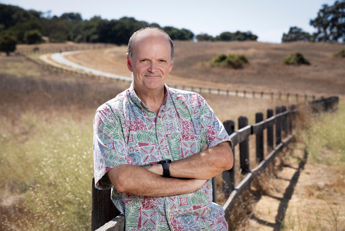 Luc Julia, CTO de Samsung, dans un parc à Stanford, Californie, posant devant une clôture en bois par une journée ensoleillée.