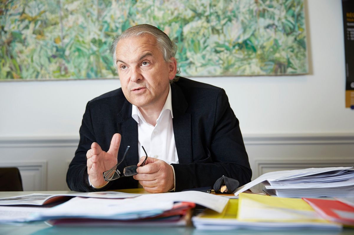 Remy Pagani, maire de Genève, assis à un bureau avec des dossiers et des documents devant lui, le 25 avril 2013.