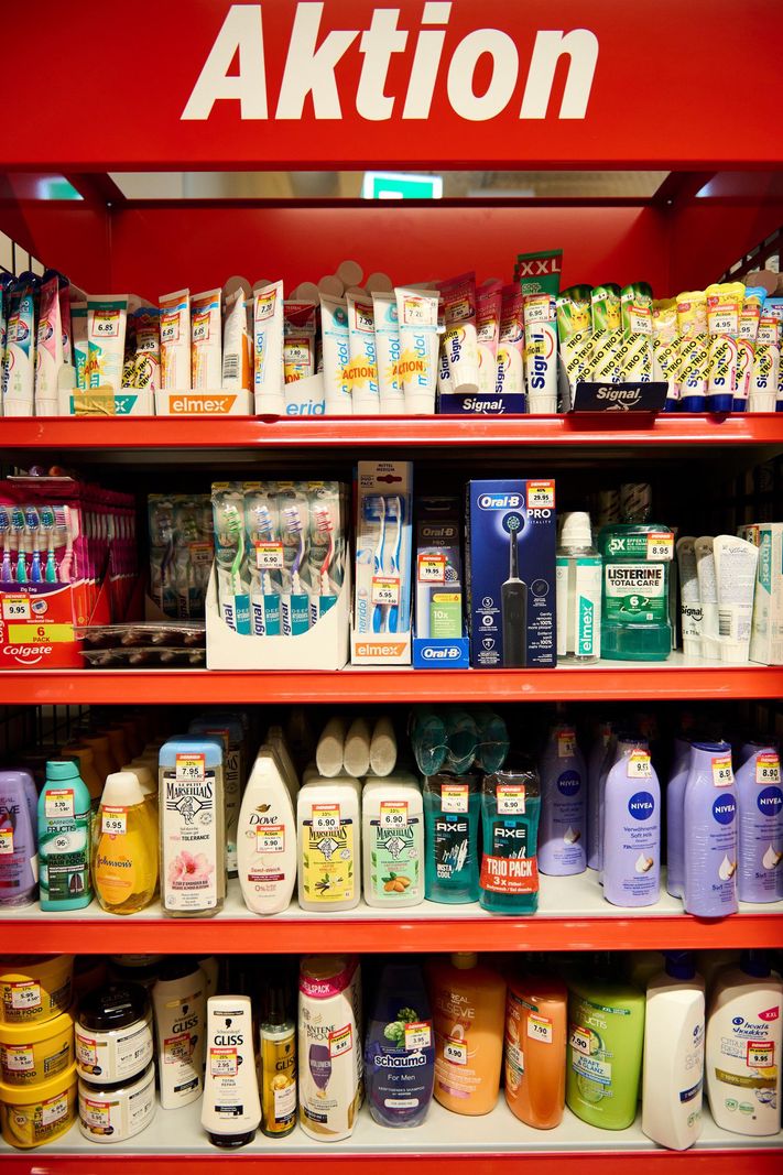 Regal with‍ various drugstore items and action prices in a supermarket.