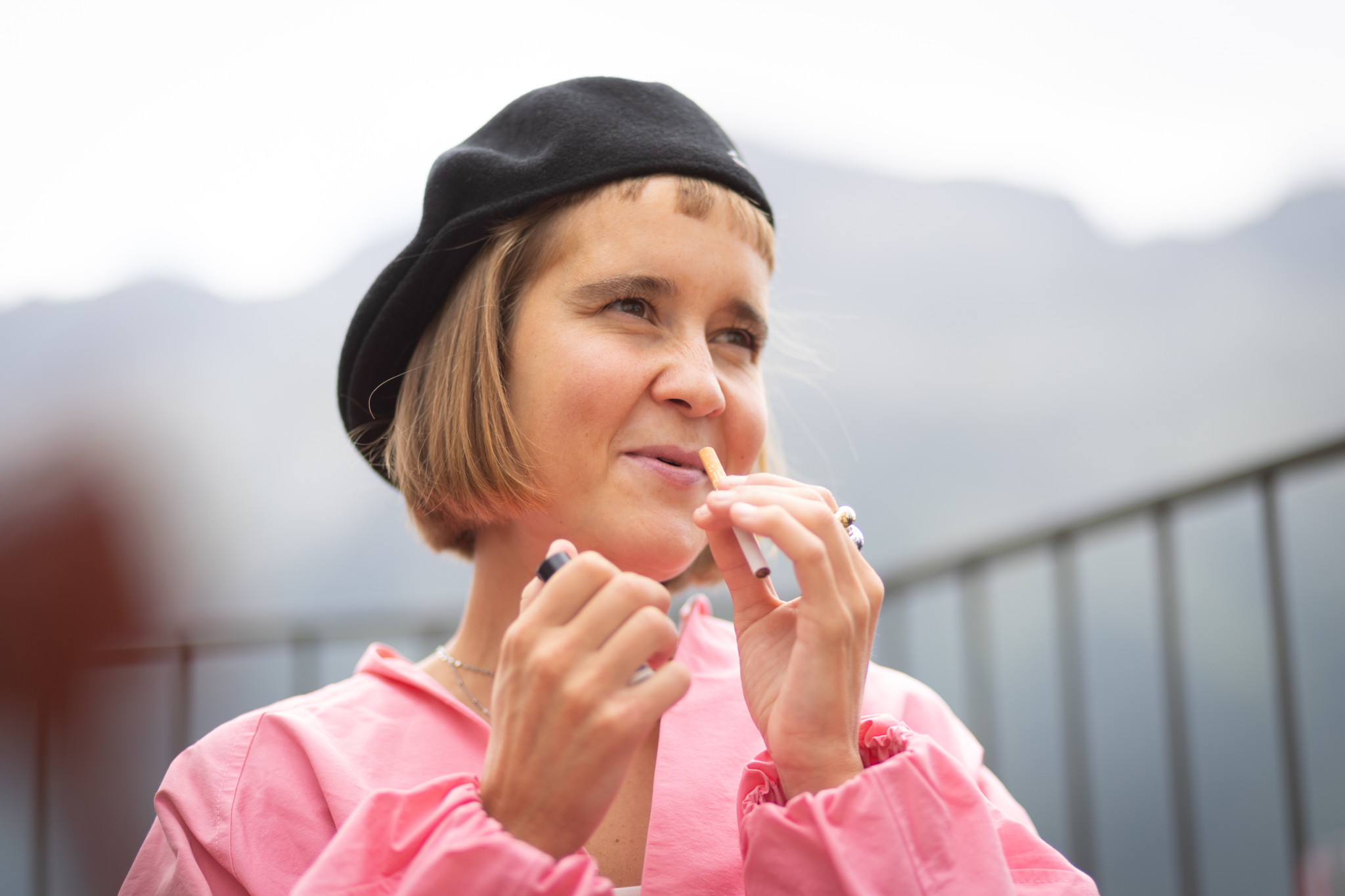 Bestsellerautorin Caroline Wahl mit schwarzem Barett und rosa Bluse vor Bergkulisse in St. Moritz.