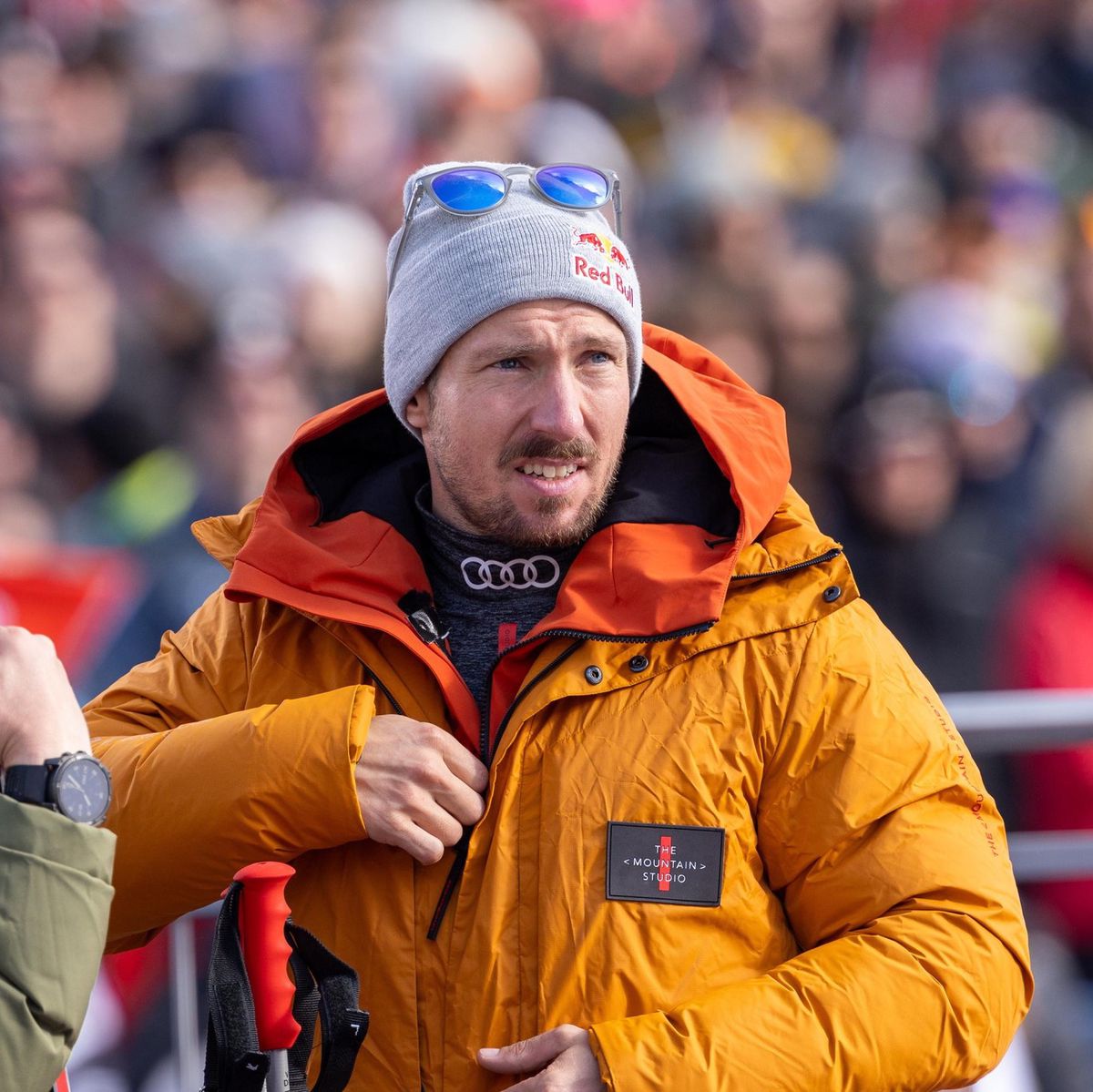 Marcel Hirscher en veste orange lors du géant masculin à Sölden, Autriche, avec des skis en arrière-plan.
