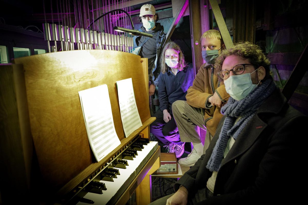 Genève, 16 mars 2021. Dans le tout petit espace à l’intérieur de la flèche de la cathédrale Saint-Pierre, le carillonneur Vincent Thévenaz, devant son instrument, s’apprête à jouer avec le groupe pop Le Cosmo Club, soit Léon, Augustin et Nelson.