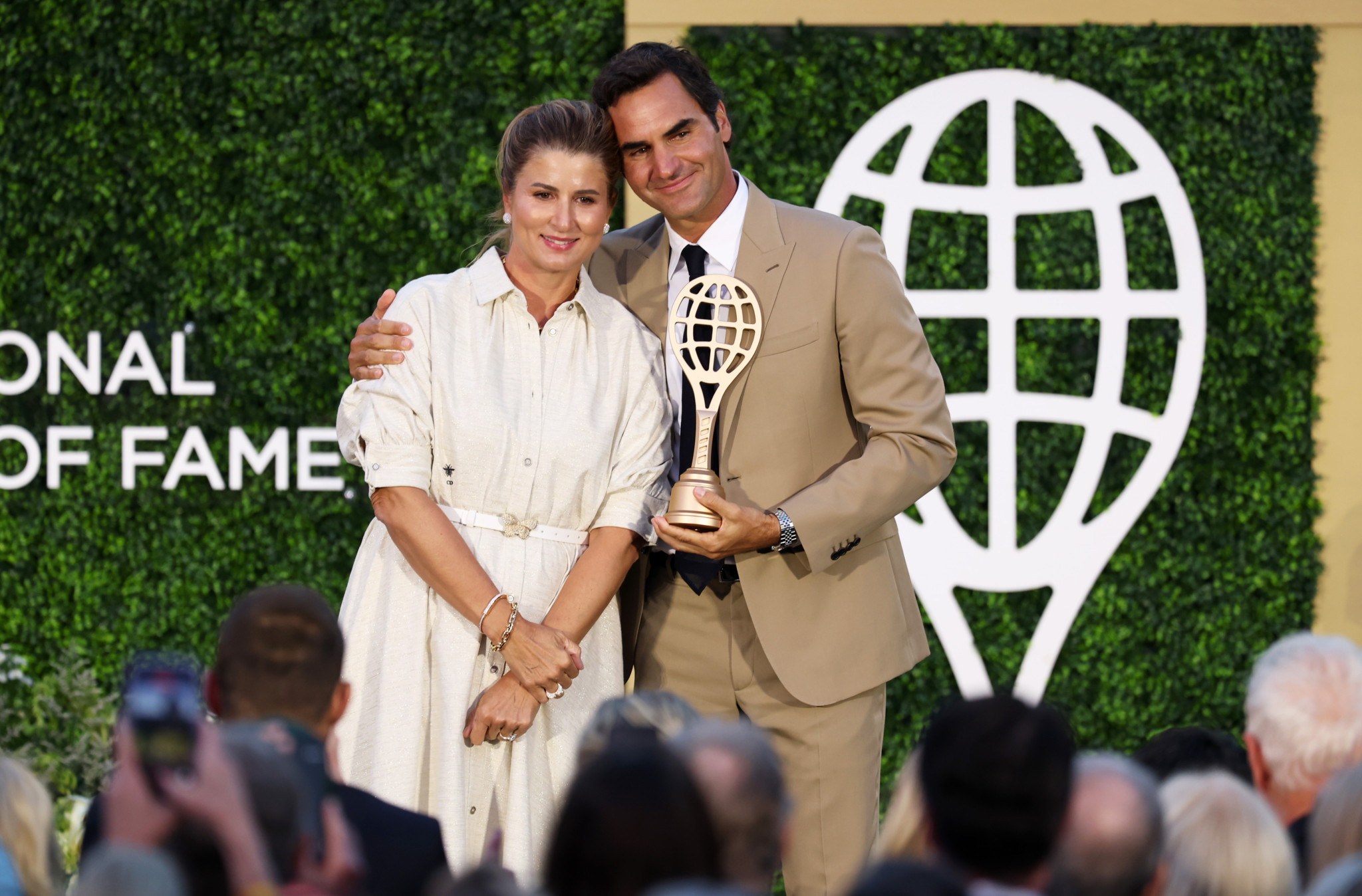 Roger Federer hält die Aufnahmetrophäe der International Tennis Hall of Fame 2026 und posiert mit seiner Frau Mirka Federer in Newport, Rhode Island.