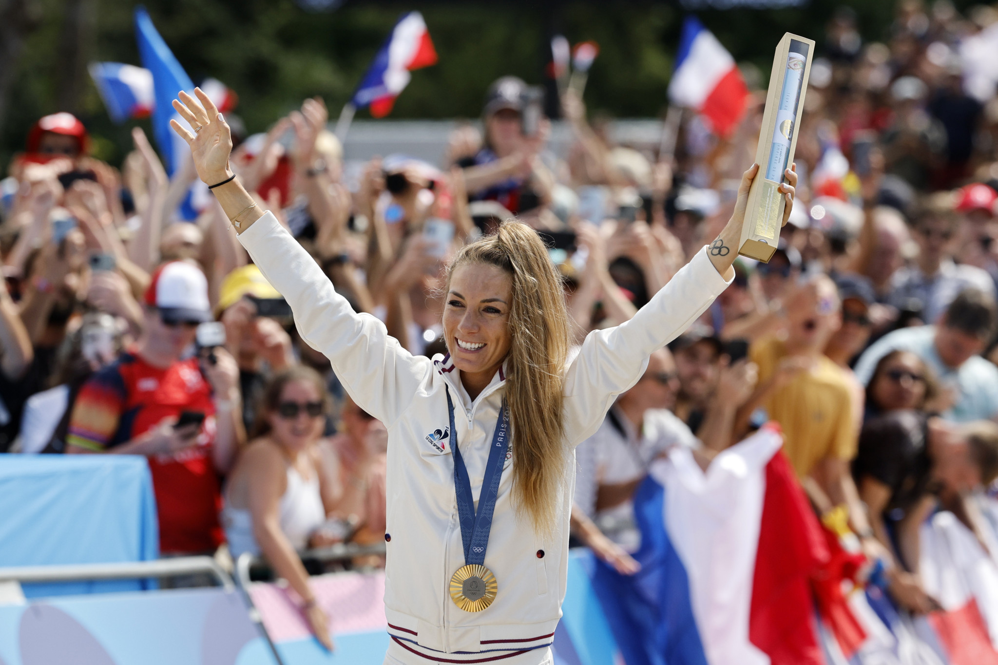 epa11502774 Gold medallist Pauline Ferrand Prevot of France celebrates on the podium after the Women Cross-Country of the Cycling BMX Racing competitions in the Paris 2024 Olympic Games, at the BMX Stadium in Saint-Quentin-en-Yvelines, France, 28 July 2024.  EPA/ERIK S. LESSER
