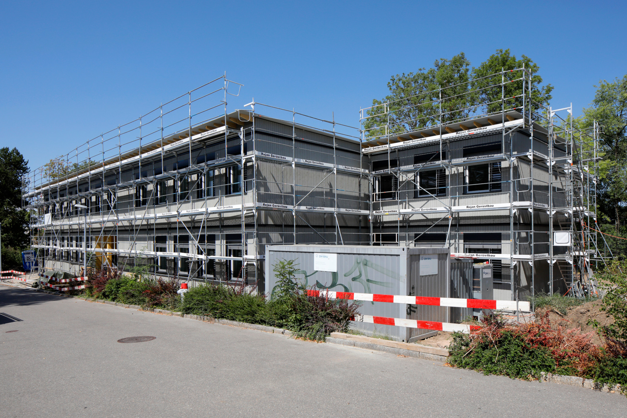 Baustelle des provisorischen Betreuungshauses Rüterwis in Zollikerberg, eingerüstetes Gebäude mit gestoppten Bauarbeiten wegen Zahlungsschwierigkeiten.