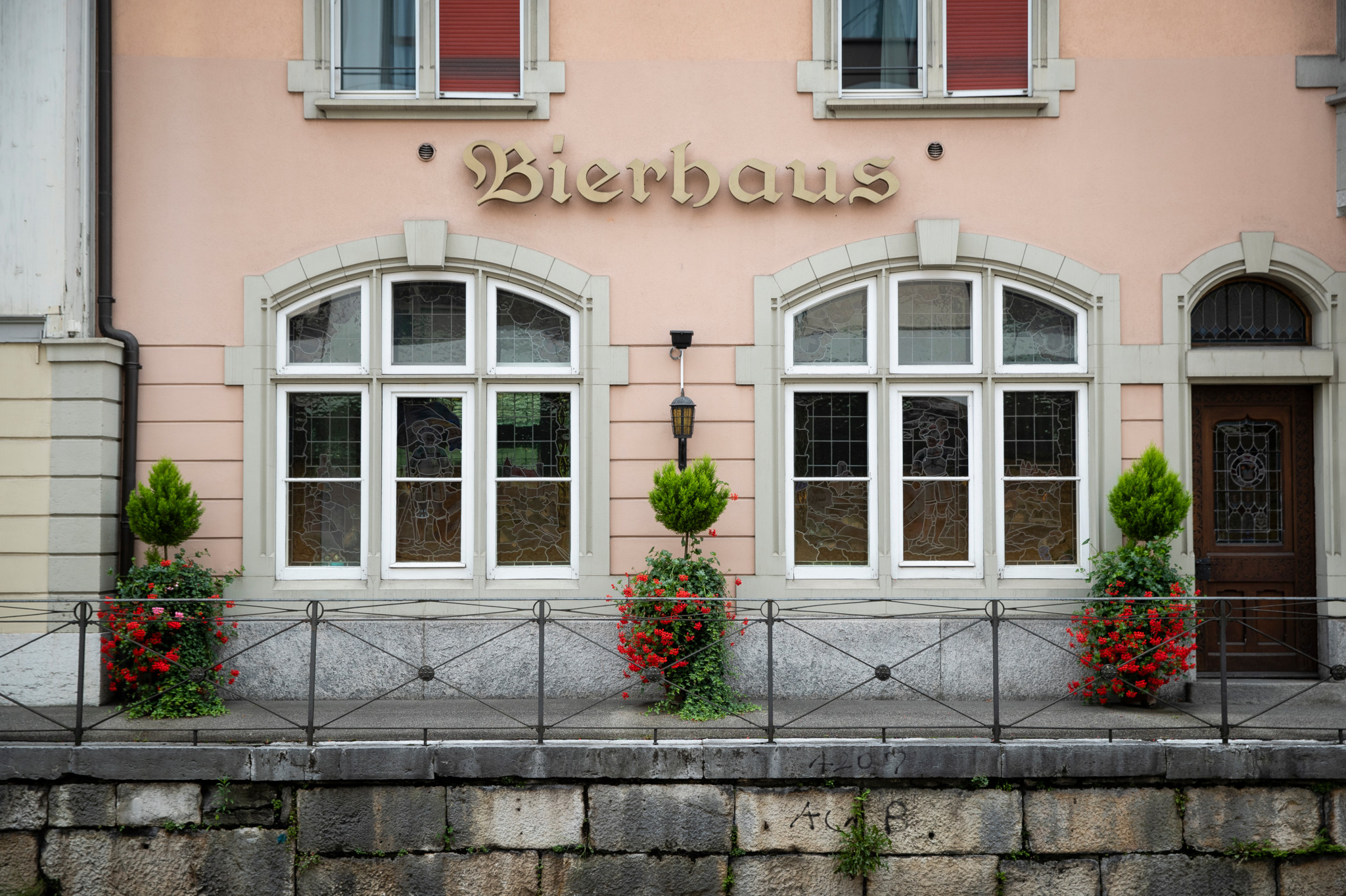 Fassade des Restaurant Braui in Langenthal mit dem Schriftzug «Bierhaus», weissen Bogenfenstern und roten Blumen vor der Steinmauer. Fassade des Restaurant Braui in Langenthal mit dem Schriftzug «Bierhaus», weissen Bogenfenstern und roten Blumen vor der Steinmauer.