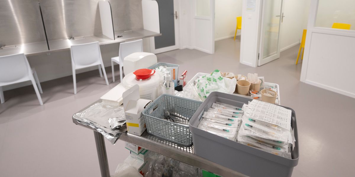 Salle d'inhalation de la Riponne à Lausanne, bien ventilée avec plusieurs postes de consommation et une table en premier plan avec divers équipements médicaux et sanitaires.