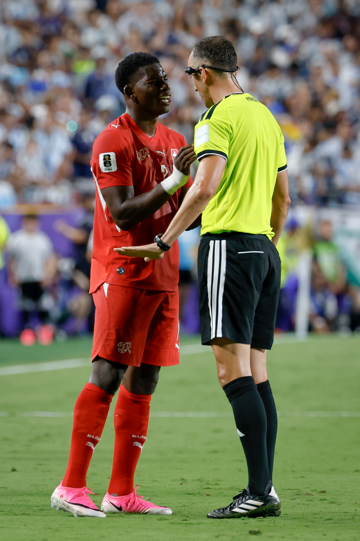 Breel Embolo im roten Schweizer Trikot diskutiert mit Schiedsrichter Joao Pedro Silva Pinheiro vor seinem Platzverweis per VAR, WM 2026. Breel Embolo im roten Schweizer Trikot diskutiert mit Schiedsrichter Joao Pedro Silva Pinheiro vor seinem Platzverweis per VAR, WM 2026.