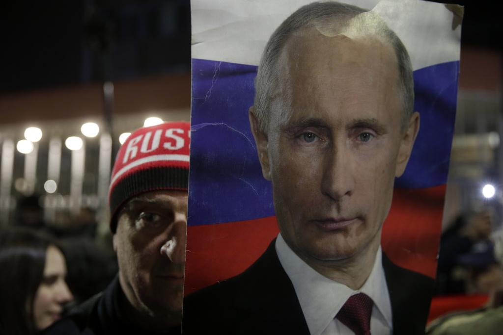 epa09802013 A protester rallying in support of Russia holds a photo of Russian President Vladimir Putin in Belgrade, Serbia, 04 March 2022. Russian troops entered Ukraine on 24 February prompting the country's president to declare martial law and triggering severe economic sanctions on Russia imposed by Western countries. EPA/ANDREJ CUKIC