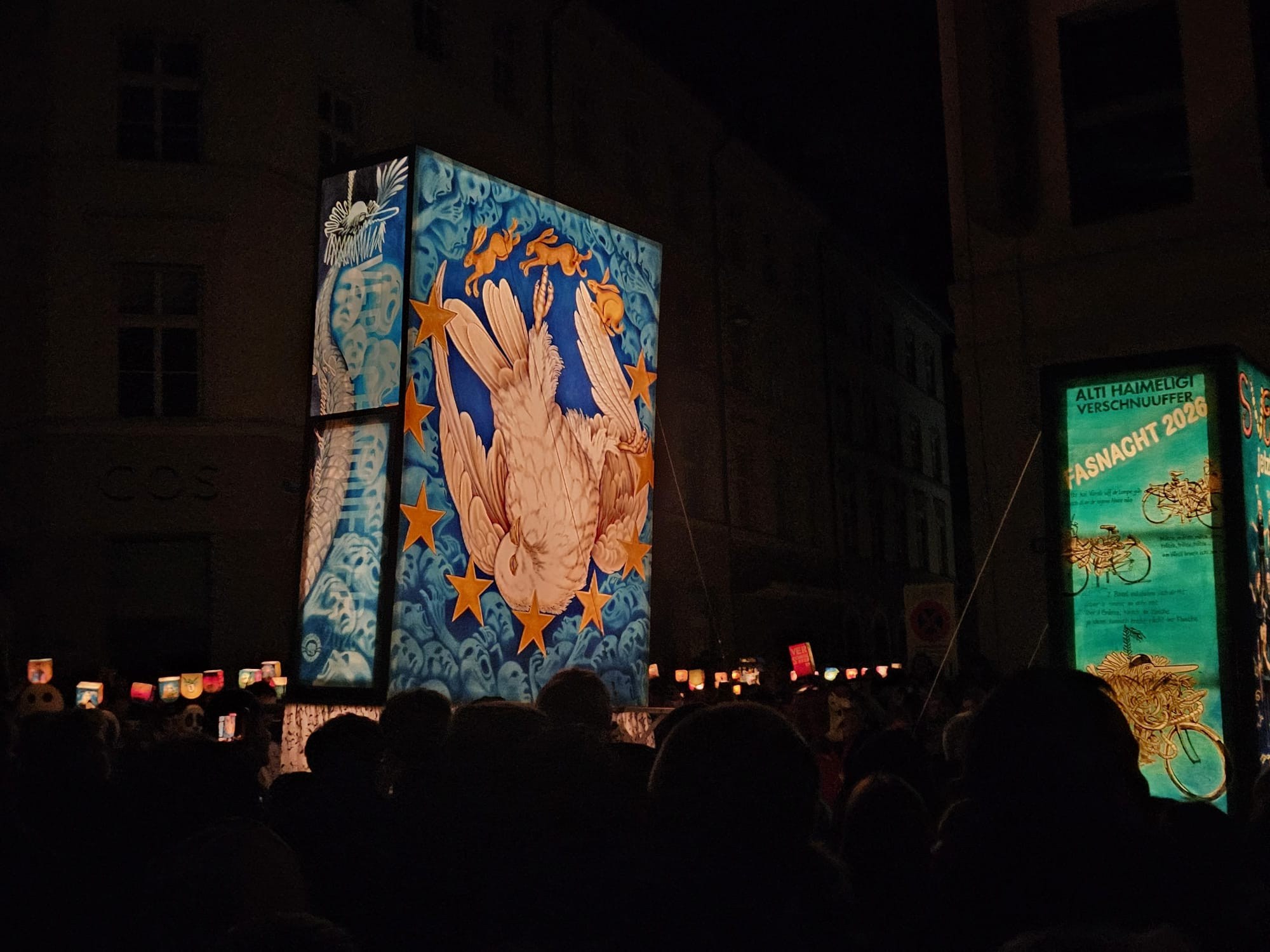 Motifs lumineux lors d'un défilé de rue nocturne avec des dessins élaborés d'oiseaux et d'étoiles lors d'un festival en Suisse.