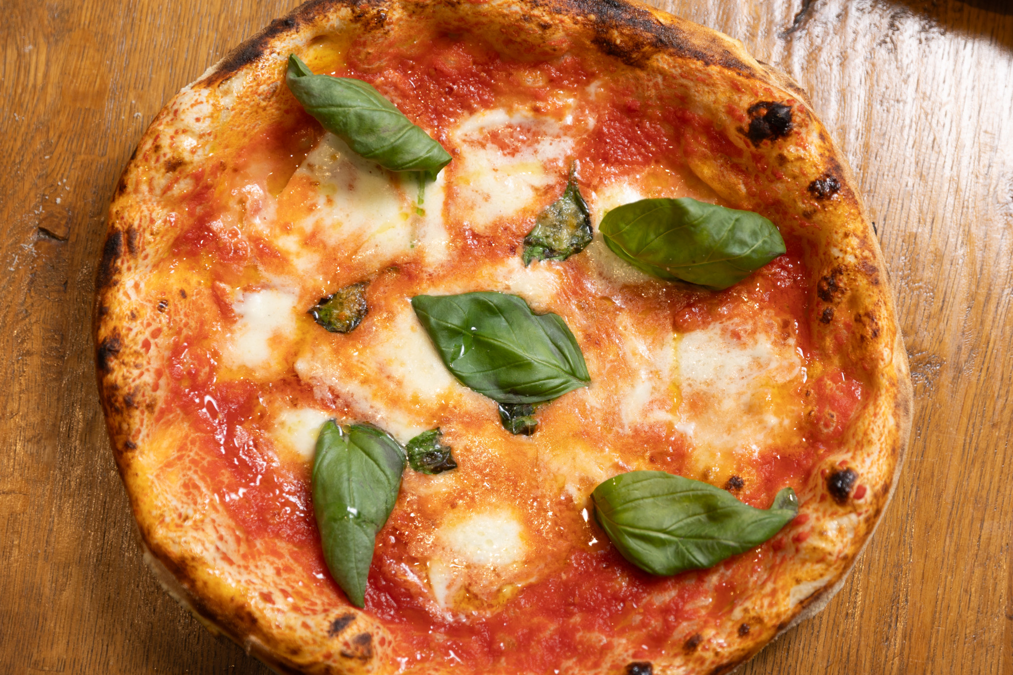 Pizza auf einem Holztisch.