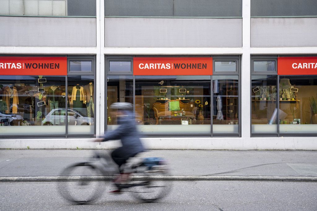 Un magasin Caritas dans la rue Bleicherstrasse du quartier Neustadt à Lucerne, photographié le lundi 29 avril 2024, avec une personne à vélo passant devant.