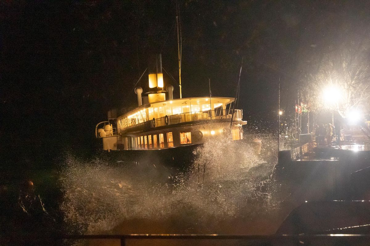 Le bateau Le Simplon de la CGN, amarré à Cully, balloté par le vent et les vagues, avec des pompiers tentant de limiter les dégâts.