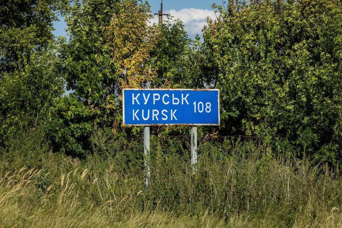 Panneau routier indiquant ’Kursk – 108 km’ près de la frontière Ukraine-Russie, avec des arbres en arrière-plan, août 2024.