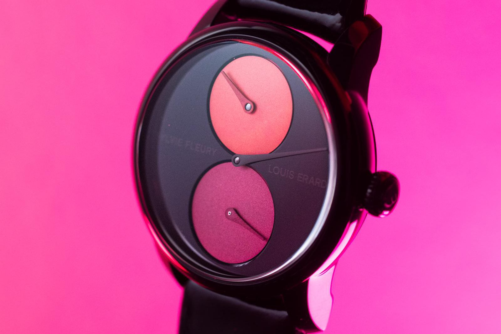 Montre design avec cadran rose et violet sur fond rose vif.