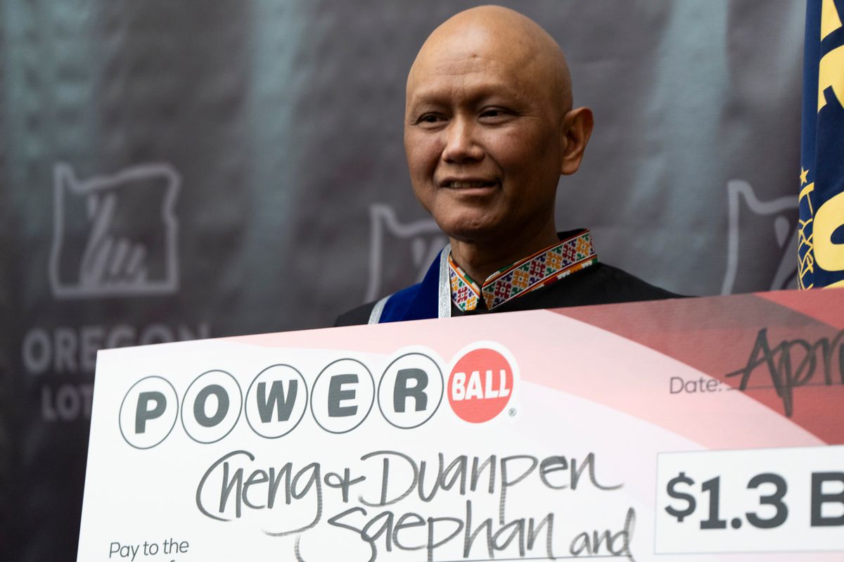 Cheng "Charlie" Saephan holds display check during a news conference where it was revealed that he was one of the winners of the $1.3 billion Powerball jackpot at the Oregon Lottery headquarters on Monday, April 29, 2024, in Salem, Ore. (AP Photo/Jenny Kane)