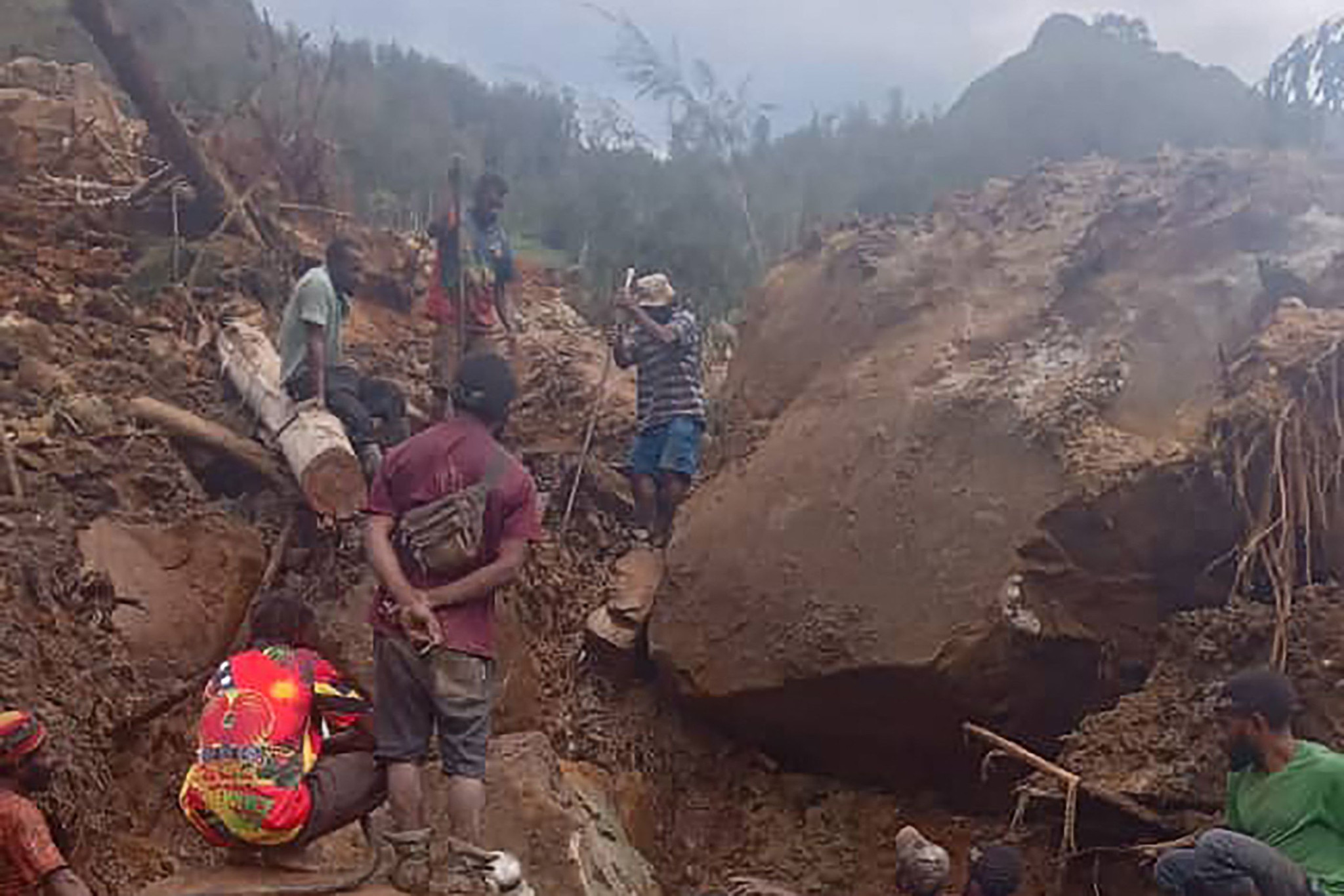 This handout photo taken on May 26, 2024 and received on May 27 courtesy of local community leader Steven Kandai shows people digging at the site of a landslide at Mulitaka village in the region of Maip Mulitaka, in Enga Province, Papua New Guinea. More than 2,000 people have been buried in a Papua New Guinea landslide that destroyed a remote highland village, the government warned May 27 as it called for international help in the rescue effort. (Photo by Handout / COURTESY OF STEVEN KANDAI / AFP) / RESTRICTED TO EDITORIAL USE - MANDATORY CREDIT "AFP PHOTO / COURTESY OF STEVEN KANDAI - NO MARKETING NO ADVERTISING CAMPAIGNS - DISTRIBUTED AS A SERVICE TO CLIENTS - NO ARCHIVE