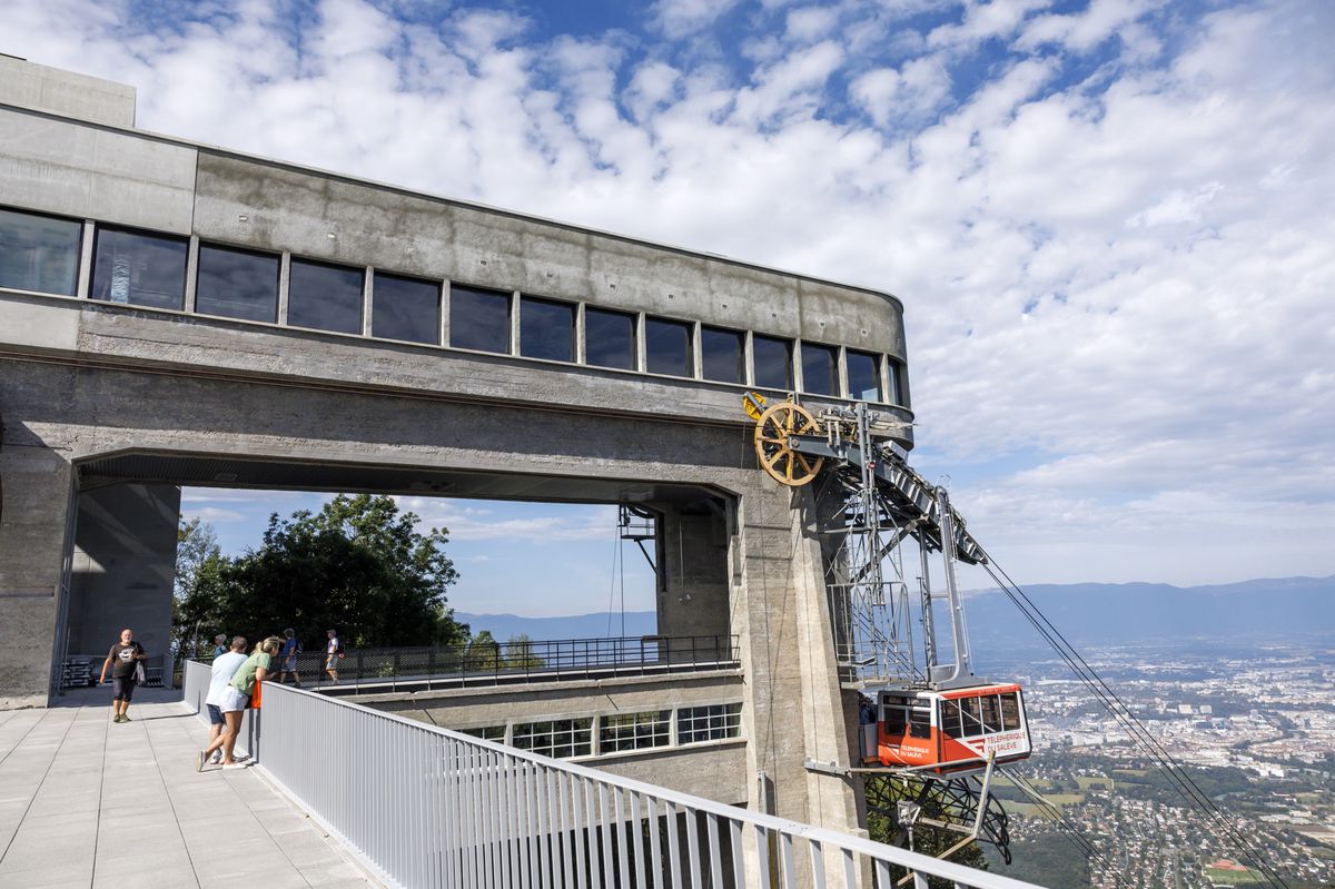 Des personnes profitent des installations de la gare d'arrivée du téléphérique du Salève lors de sa réouverture, ce mardi 12 septembre 2023 à Etrembières (France) près de Genève. Le téléphérique du Salève réouvre ce jour au public après deux années de travaux pour une réhabilitation complète des deux gares. (KEYSTONE/Salvatore Di Nolfi)