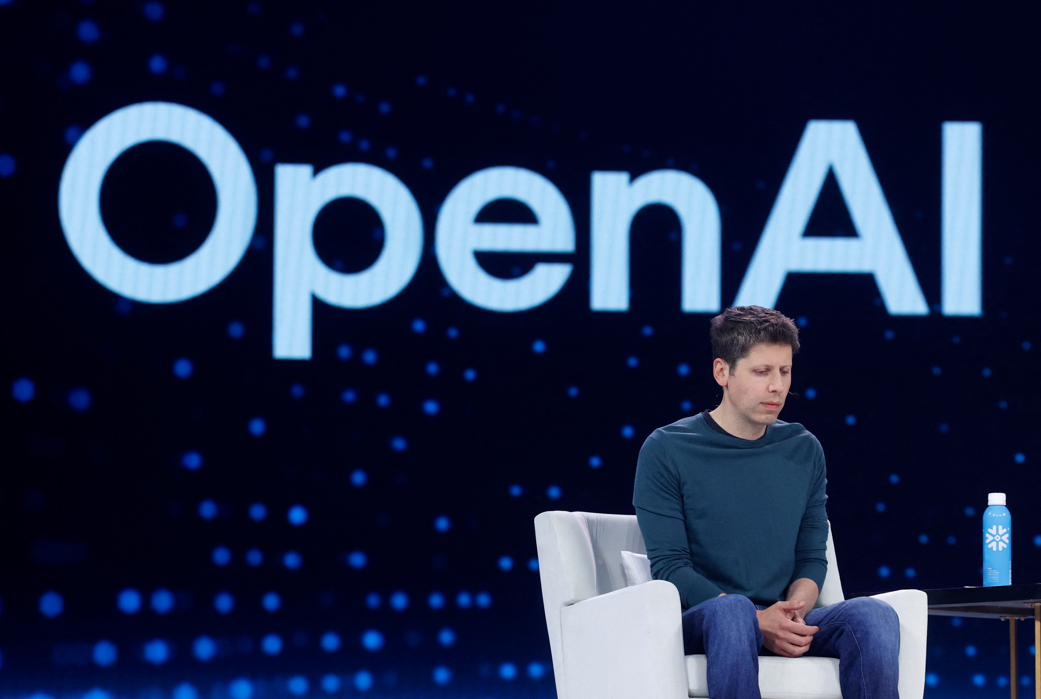 Sam Altman, PDG d’OpenAI, assis sur scène devant un grand écran affichant le logo OpenAI lors du Snowflake Summit 2025 à San Francisco.