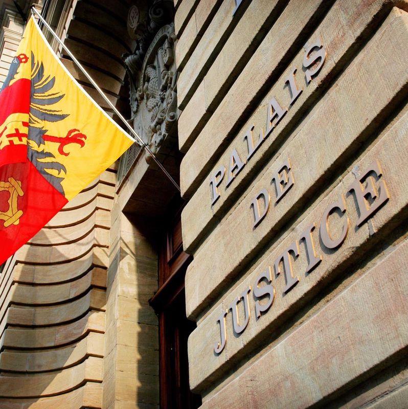 Façade du Palais de Justice avec drapeau genevois sur le mur.