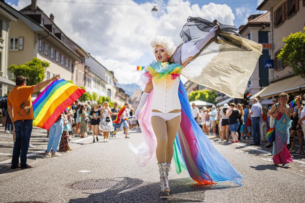 Des personnes font la fête dans la rue lors d’une marche des fiertés à la Pride de Bulle, en Suisse, samedi 25 juin 2022.
