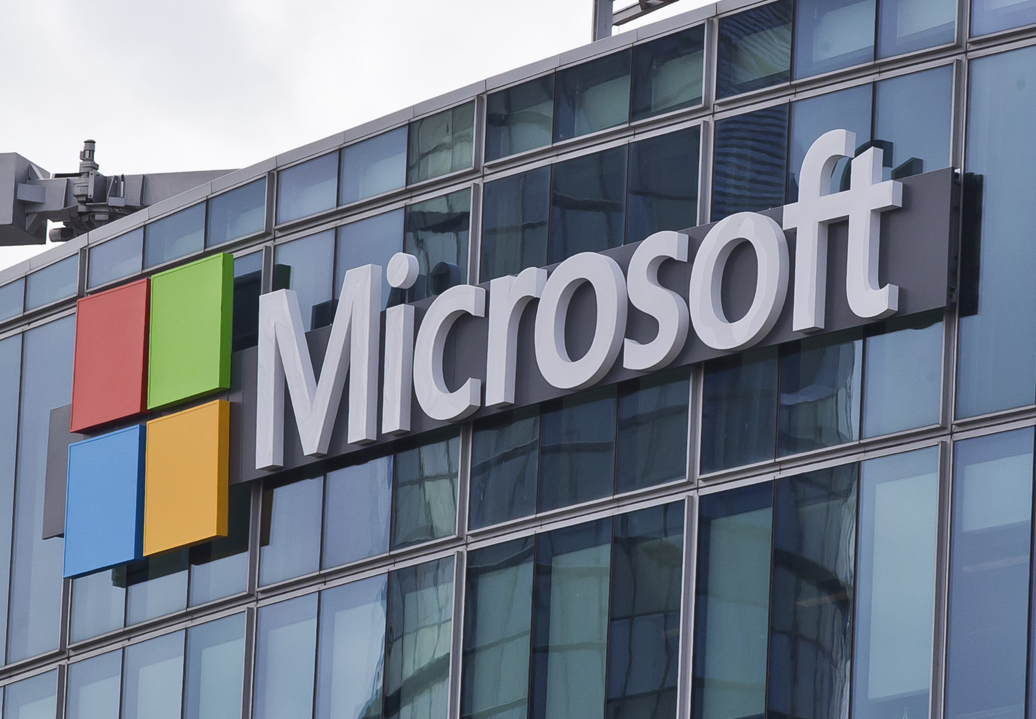 Microsoft-Logo mit dem farbigen Windows-Symbol an der Fassade eines Glasgebäudes in Issy-les-Moulineaux bei Paris.