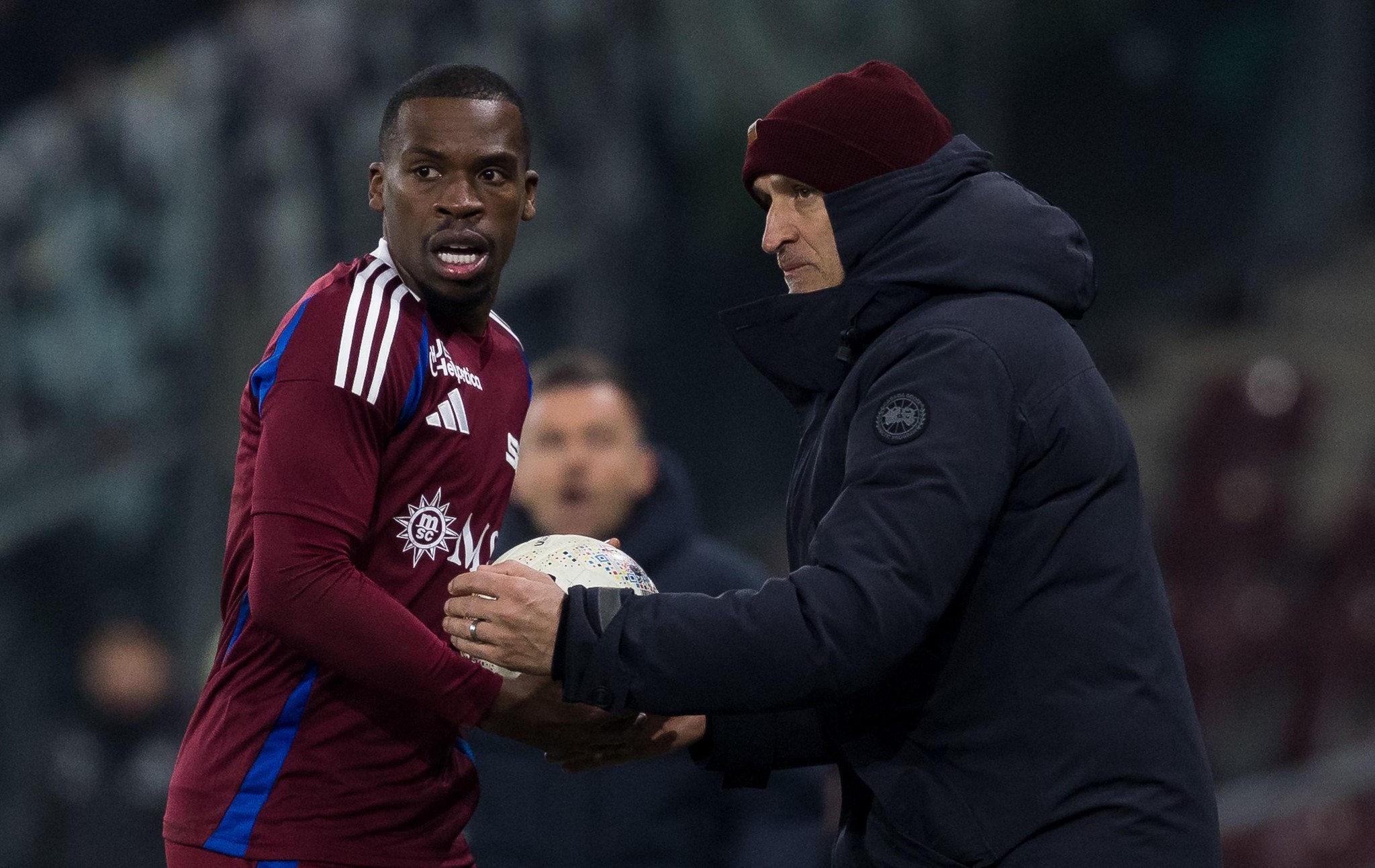 Un joueur du SFC et un entraîneur en veste noire échangent un ballon lors d’un match contre Saint-Gall, le 18 janvier 2025.